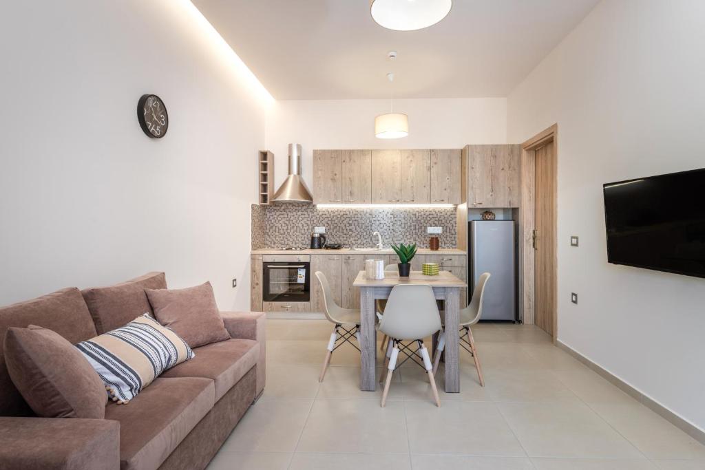 ein Wohnzimmer mit einer Couch und einem Tisch in der Unterkunft Katsaros Luxury Apts 5 min walk to beach in Planos