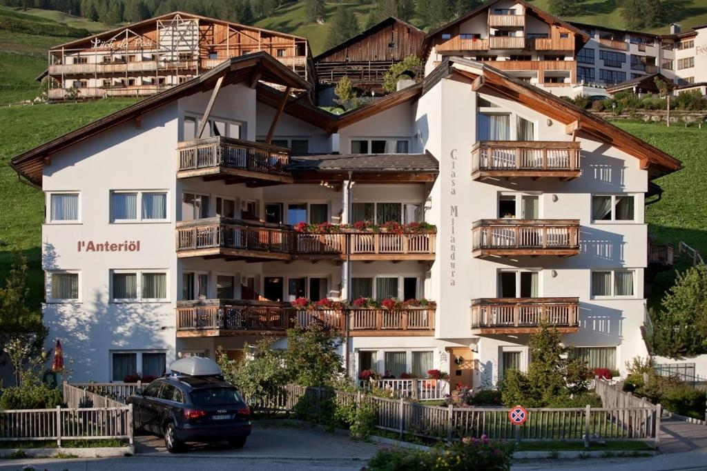 a building with a car parked in front of it at Ciasa Anteriol in San Cassiano