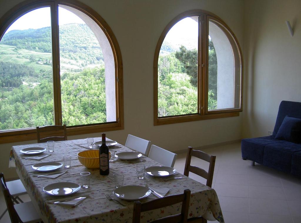 a dining room with a table and two large windows at Casa con panorama in Monticello