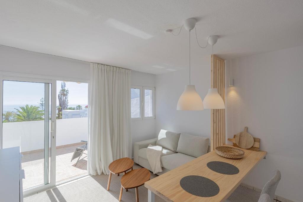 a white living room with a table and a couch at Casa Málaga by Huskalia in Tazacorte