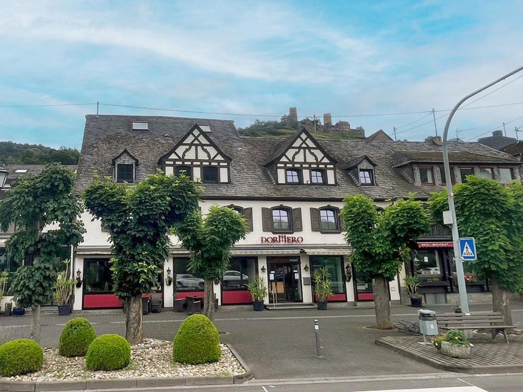 ein Gebäude in einer Stadt mit Bäumen davor in der Unterkunft DORMERO Moselhotel Koblenz-Alken in Alken