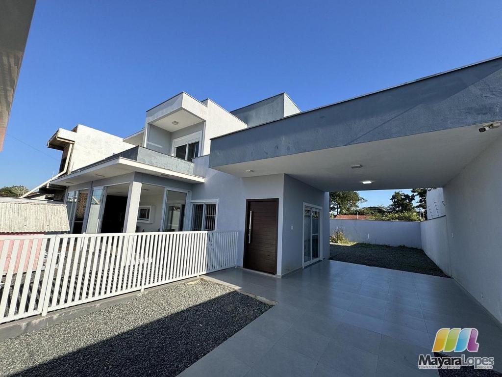 a large white house with a white fence at Refúgio na Praia Casa Confortável e Acolhedora in São Francisco do Sul
