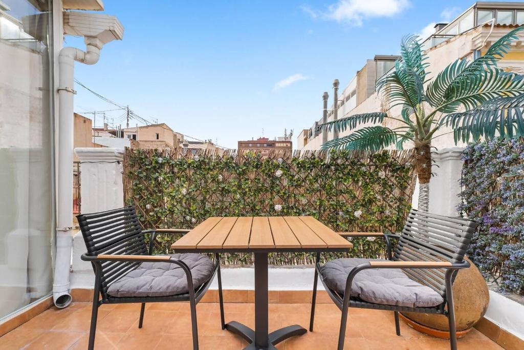 Una mesa y sillas en un balcón con valla. en LovelyLofts Cathedral Penthouse, en Alicante