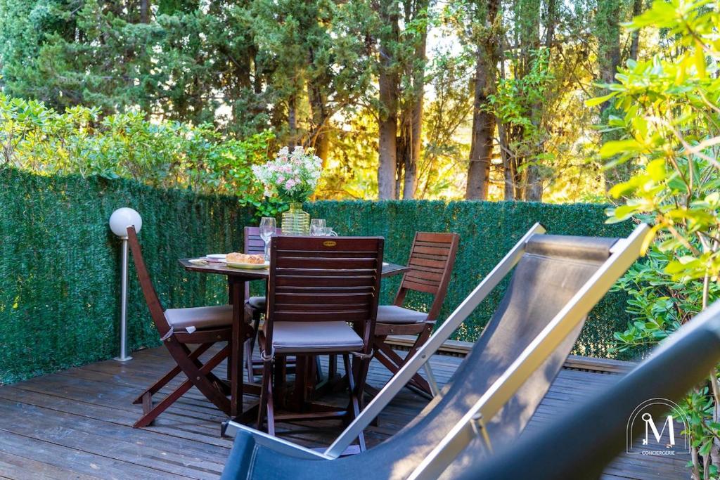 une table et des chaises sur une terrasse avec toboggan dans l'établissement Studio avec jardinet dans résidence avec piscine, à Sanary-sur-Mer