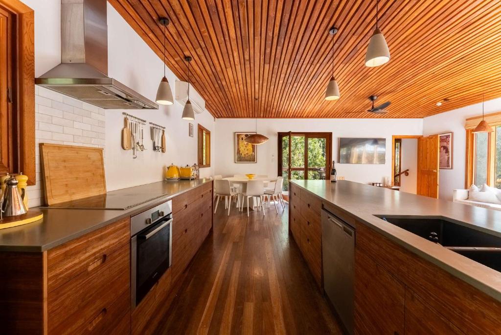 eine große Küche mit Holzschränken und einer Arbeitsplatte in der Unterkunft Stirling Creek Cottage in Stirling