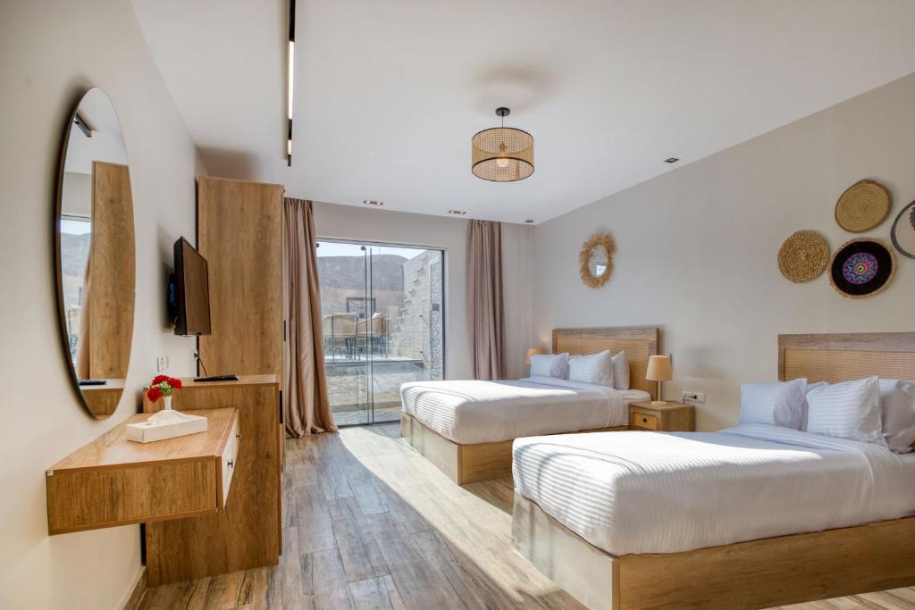 una camera d'albergo con due letti e una finestra di Beyond Pyramids View a Il Cairo