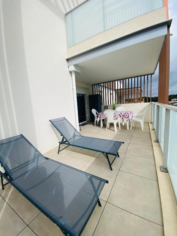 un balcon avec deux chaises et une table dans l'établissement Appartement avec terrasse et parking - v0841, à Vias