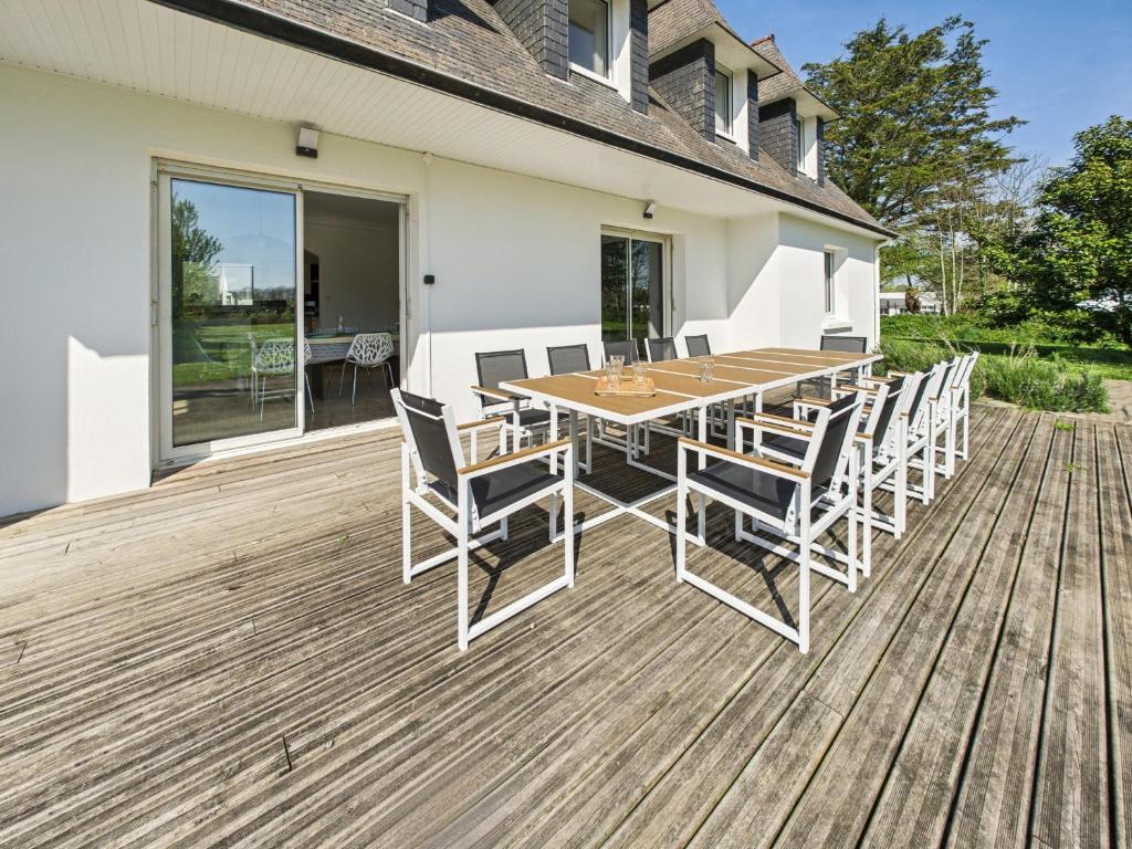 une terrasse en bois avec une table et des chaises dessus dans l'établissement Maison moderne pour 12, grand jardin, terrasse, à Concarneau