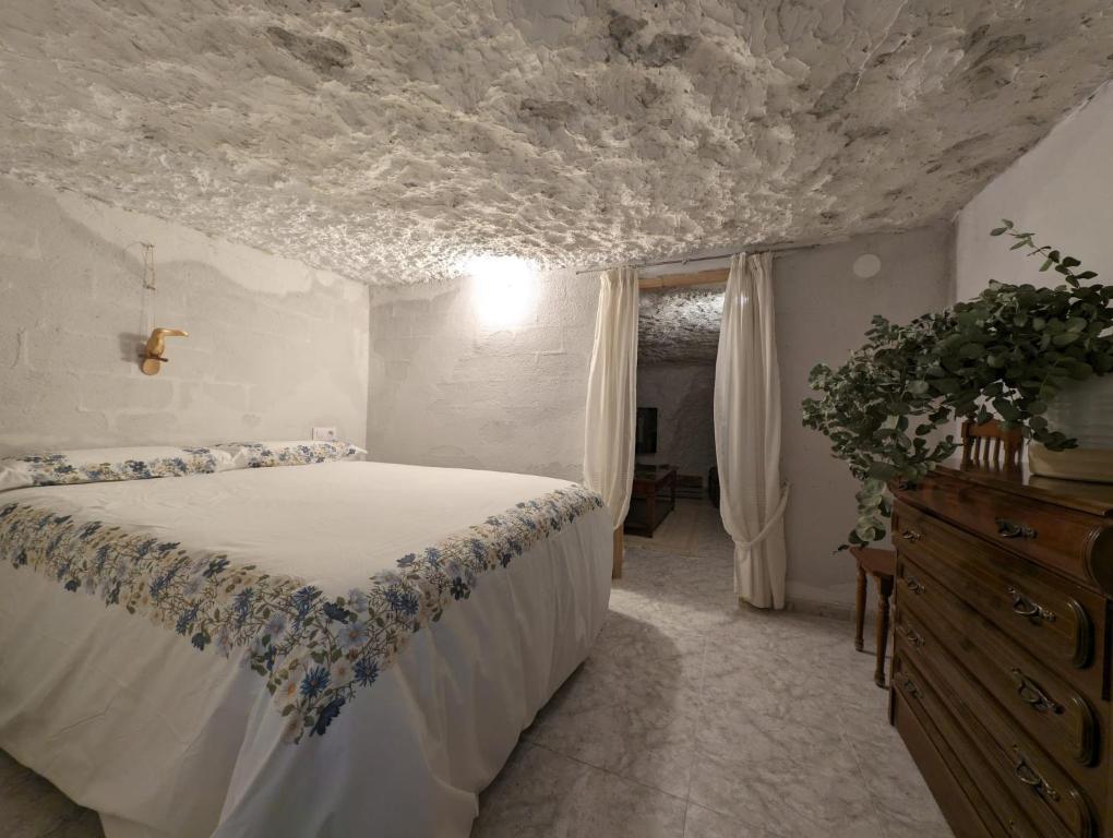 a bedroom with a bed and a ceiling decorated with flowers at Gaiamoment La casa la panadera in Alcalá del Júcar