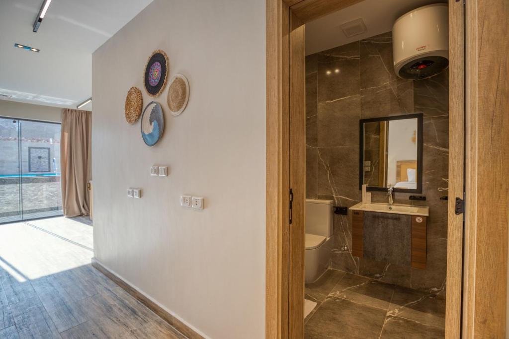 un bagno con lavandino, water e specchio di Beyond Pyramids View a Il Cairo