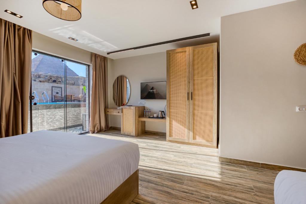 una camera da letto con un letto e una grande finestra di Beyond Pyramids View a Il Cairo