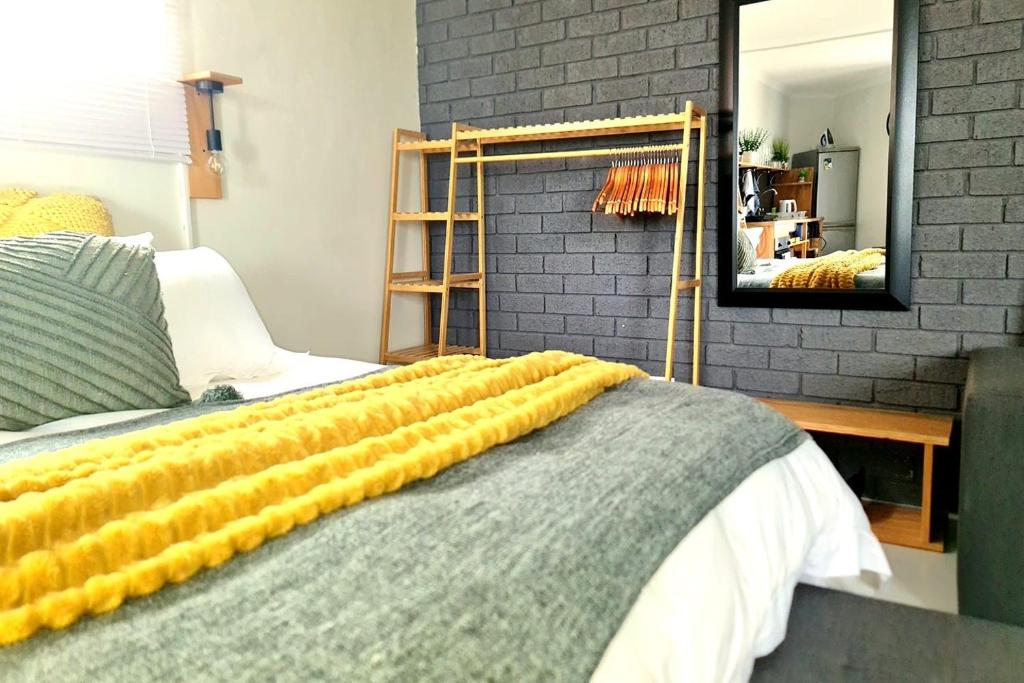 a bedroom with a bed with a yellow blanket on it at Shearwater Studio Sedgefield in Sedgefield
