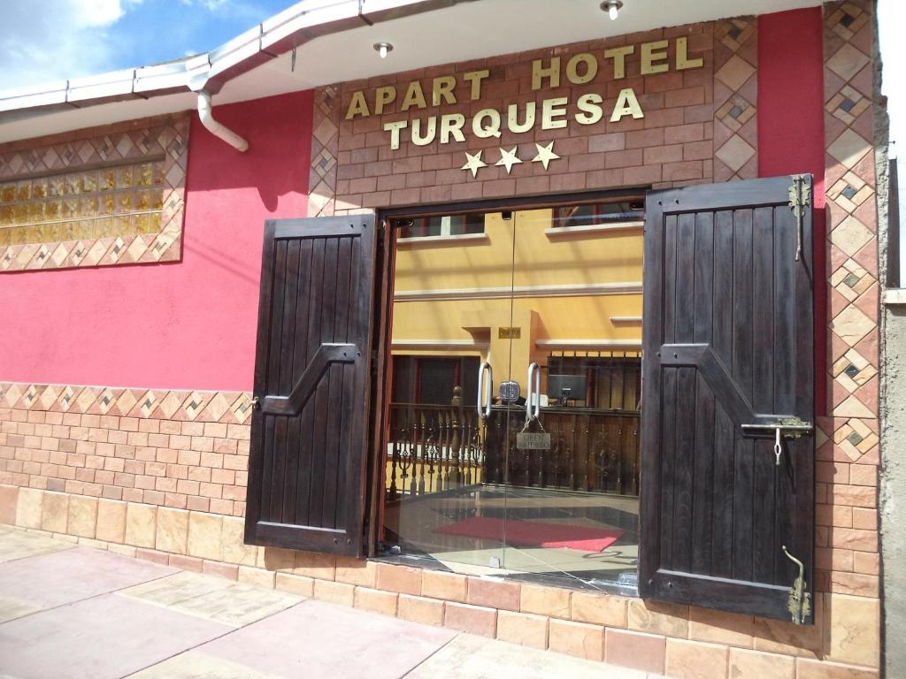 una entrada a un hotel con dos puertas de madera en Apart Hotel Turquesa en Potosí
