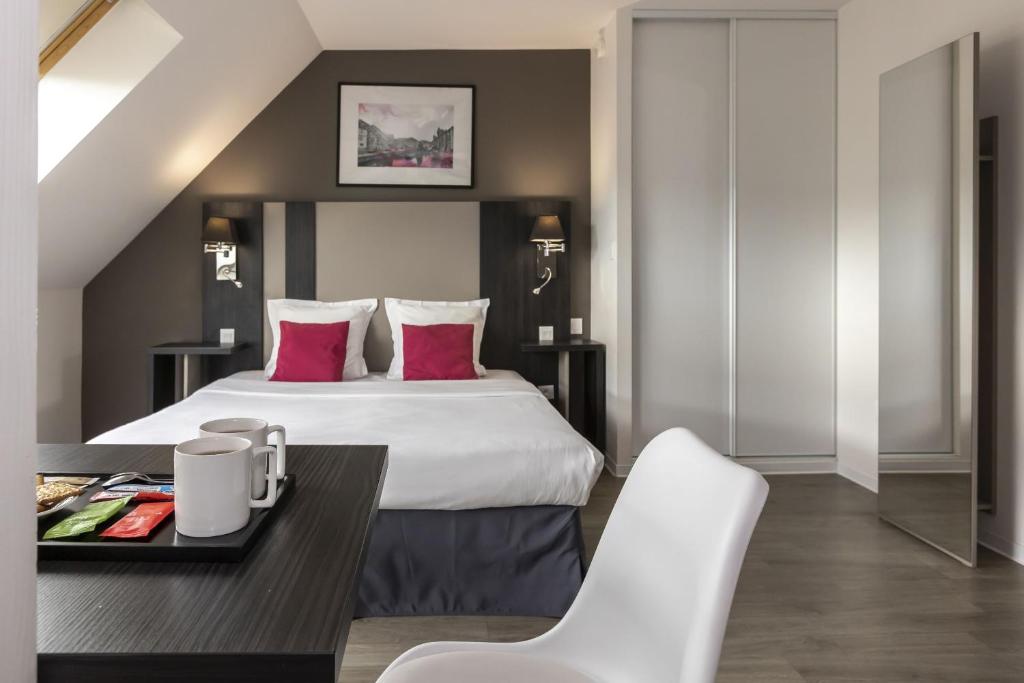 Postel nebo postele na pokoji v ubytování Appart Hotel Odalys City Colmar La Rose d'Argent