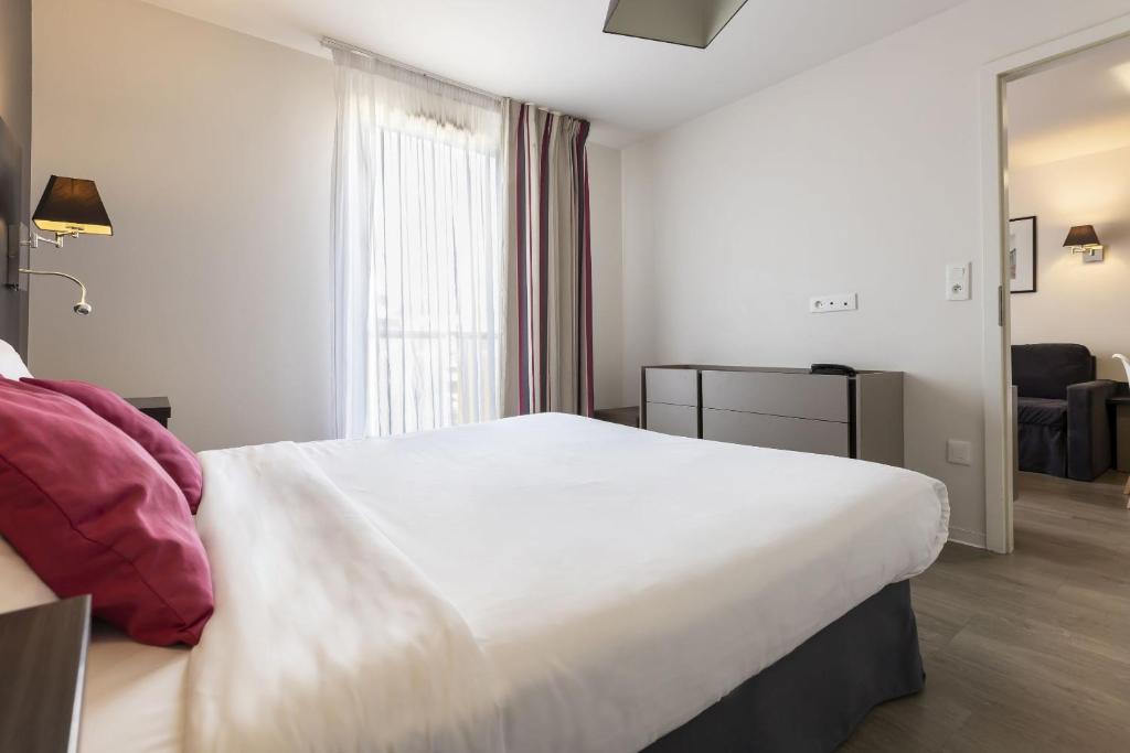 Postel nebo postele na pokoji v ubytování Appart Hotel Odalys City Colmar La Rose d'Argent