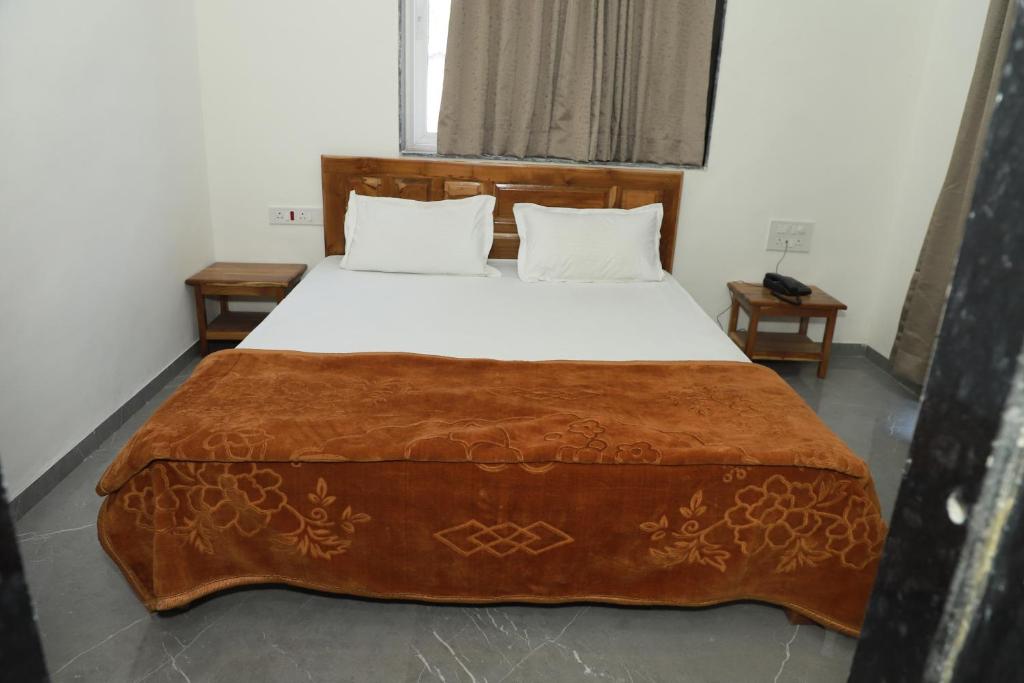 a bedroom with a large bed with a brown blanket at Hotel Rajmahal Palace Bhimashankar pune in Taleghar