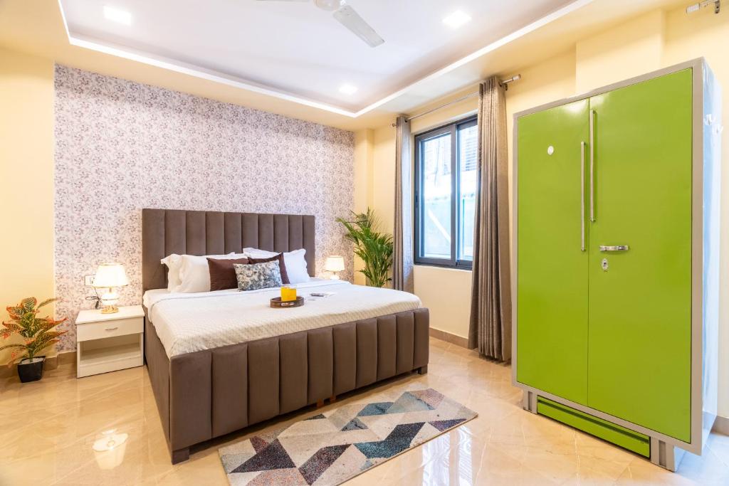 1 dormitorio con 1 cama grande y puerta verde en Homlee-Legacy 3BHK Flat in Central DEL-Lift-Terrace, en Nueva Delhi