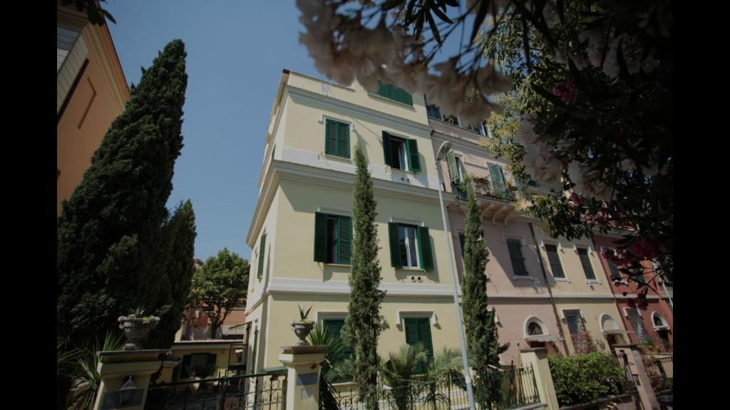 羅馬的住宿－瑪特爾德公寓，一座带绿色百叶窗的大型白色建筑