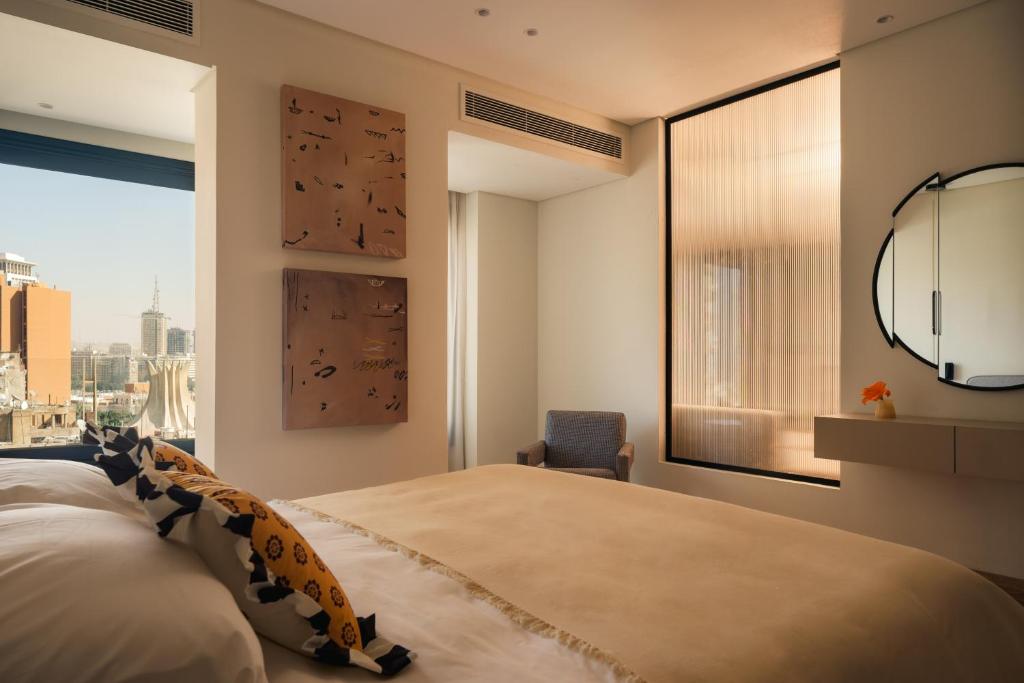 a bedroom with a large bed and a large window at Brassbell Zamalek Diplomatic Zone Near Marriott in Cairo