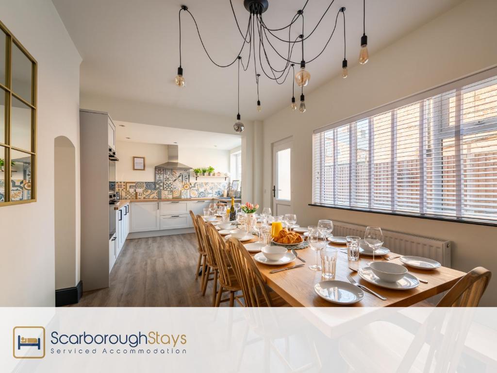 a dining room with a long table and chairs at Scarborough Stays - Darcey House in Scarborough
