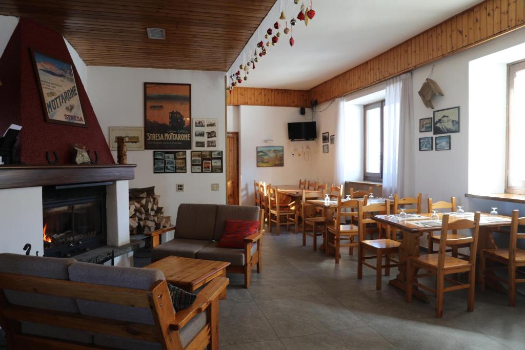 restauracja ze stołami i krzesłami oraz kominkiem w obiekcie Albergo Casa Della Neve w mieście Stresa