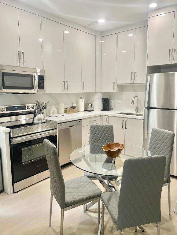 a kitchen with a glass table and chairs at Bright Luxurious 2 Bedroom Apartment in Toronto