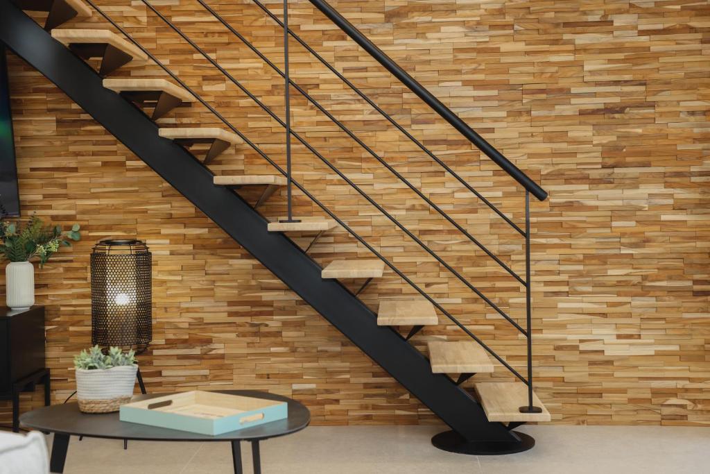 a staircase in a room with a brick wall at La Villa Léo face au Centre Equestre et Piscine in Neufchâtel-Hardelot