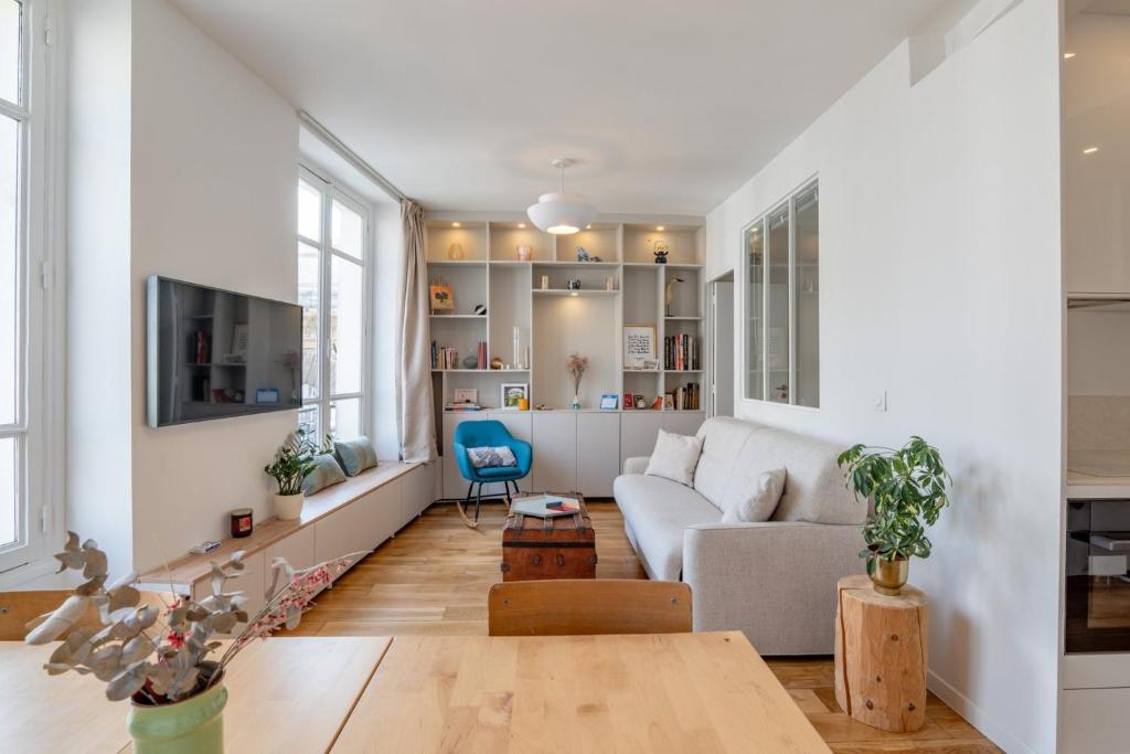 un salon avec un canapé et une table dans l'établissement Cozy Faubourg St Martin retreat, à Paris