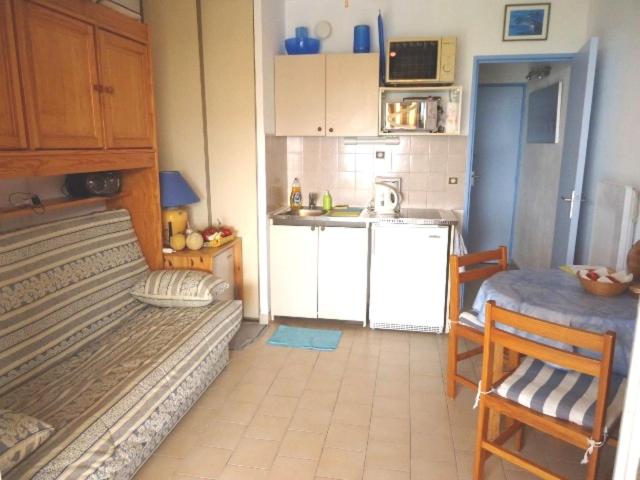 - une petite cuisine avec un lit et une petite table dans l'établissement joli studio rez de jardin résidence avec piscine, à Cavalaire-sur-Mer