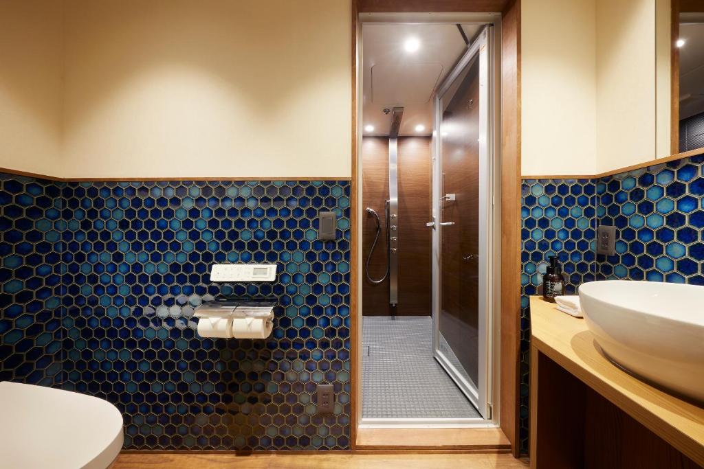 a bathroom with a shower and a toilet and a sink at Minn Nijo-jo in Kyoto