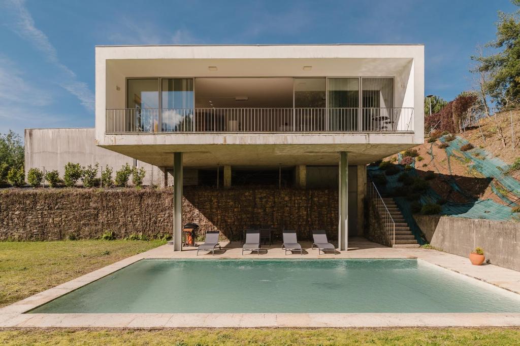 una casa con piscina di fronte a una casa di Casa Do Golf Ponte de Lima a Ponte de Lima