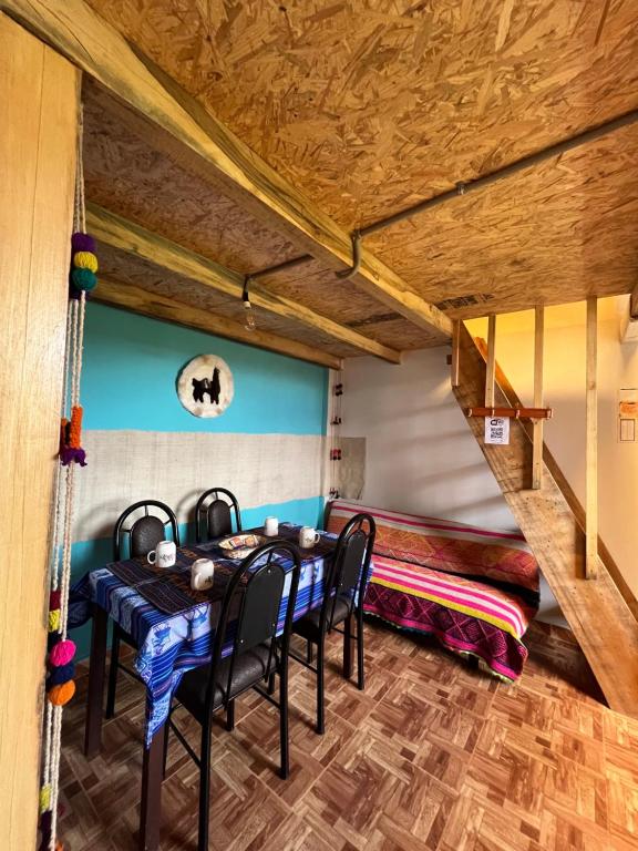 un comedor con 2 mesas y un banco en "CASITA DE GERANIOS " con cocina , sala , patio amplio y cochera privada, en Chivay