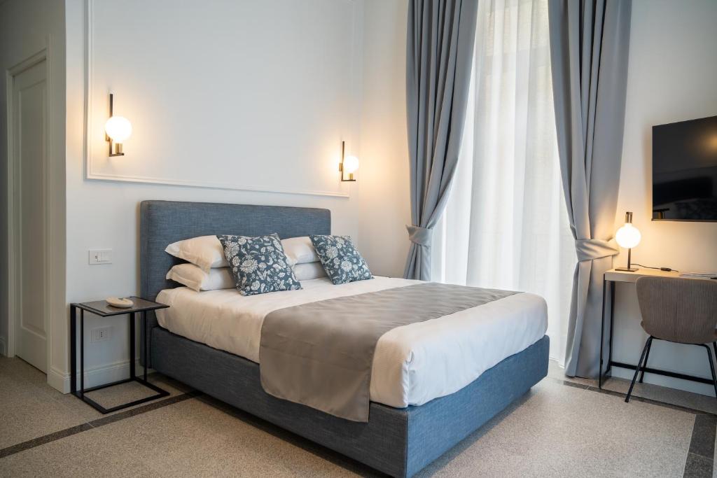 a bedroom with a large bed with blue pillows at Monteroduni 22 - Chiaia Design Rooms in Naples