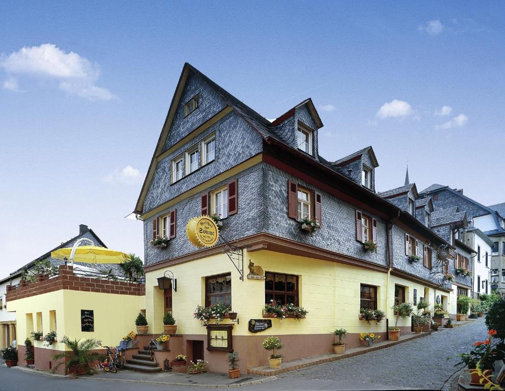 un bâtiment avec un bâtiment noir et jaune dans l'établissement Landgasthof Zur Sonne, à Enkirch