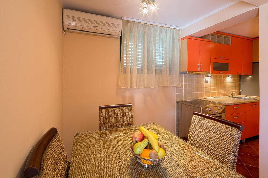 een keuken met een tafel en een fruitschaal bij Apartments Mika in Budva