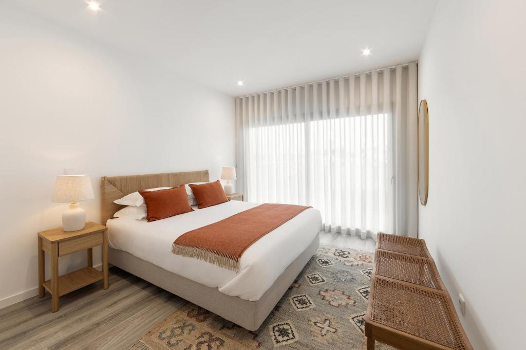 a bedroom with a large bed and a window at Casa LukStian in Nazaré