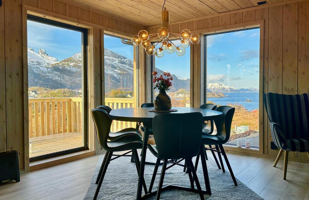a dining room with a table and chairs and a large window at Premium Chalet with Grand View in Sørvågen