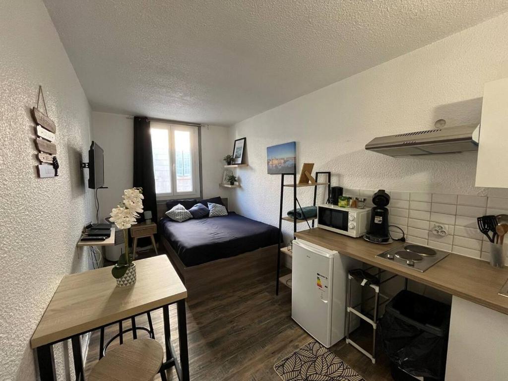 Cette petite chambre comprend un lit et une cuisine. dans l'établissement Charmant studio à proximité du Vieux-Port, à Marseille