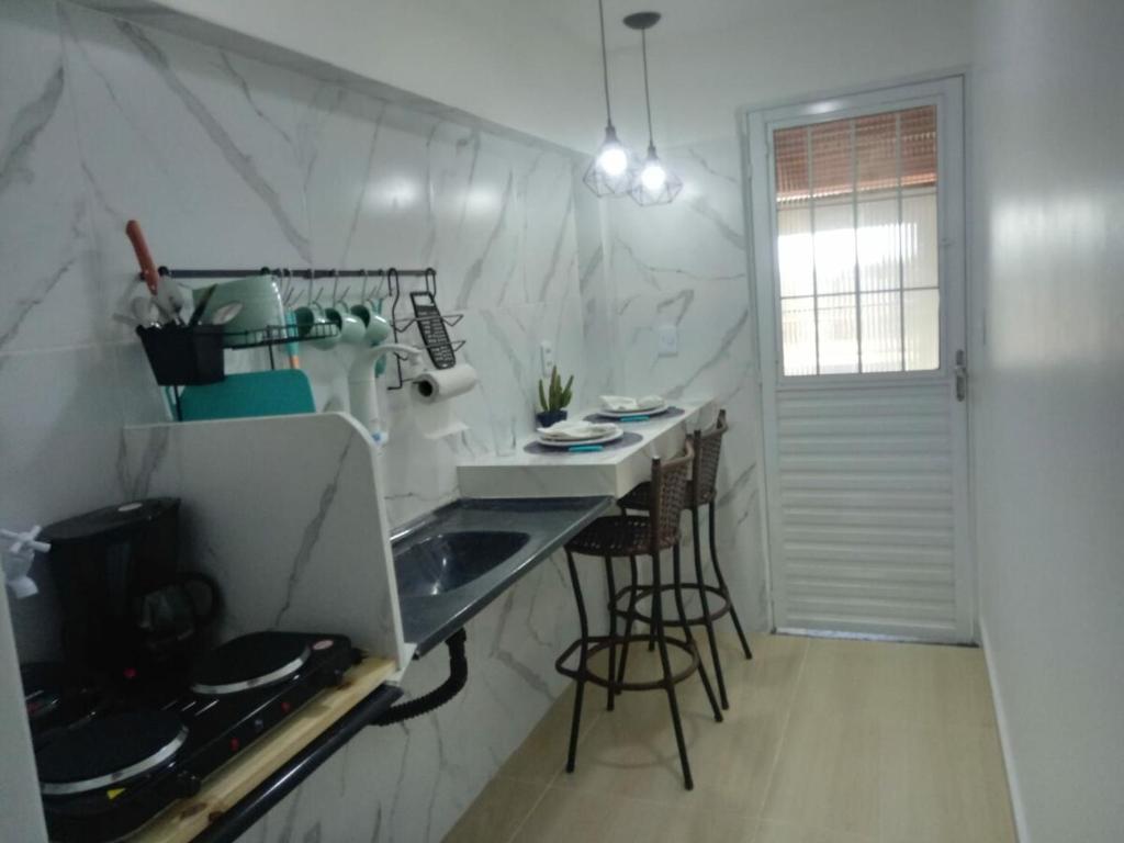 a kitchen with a sink and a counter with stools at Kitnet de luxo perto do shopping da ilha in São Luís