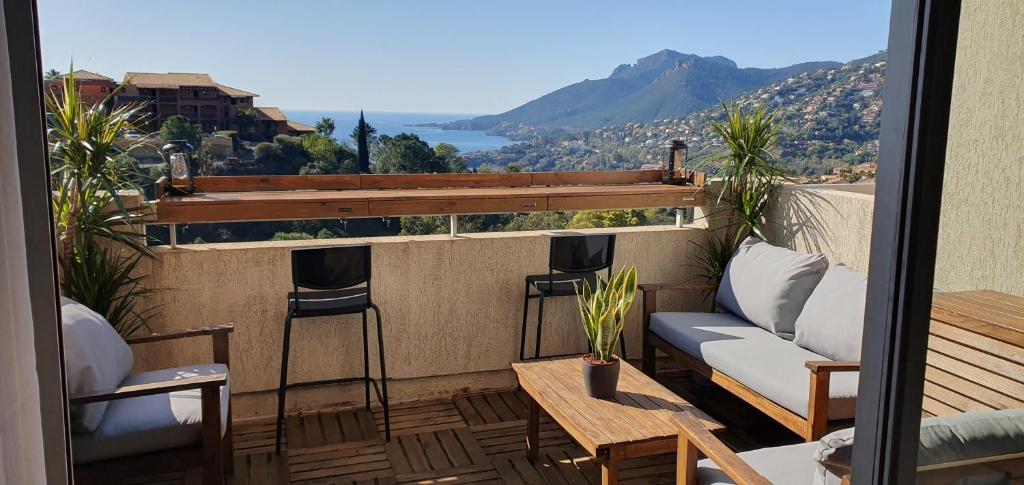 un balcon avec un canapé, une table et des chaises dans l'établissement Architect's studio with pool, sea view and AC, à Théoule-sur-Mer