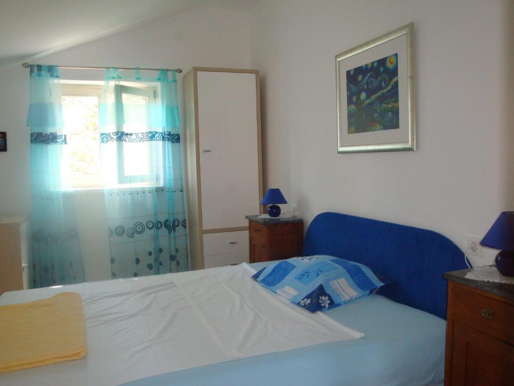 a bedroom with a blue bed and a window at Blue Lagoon Pag in Pag
