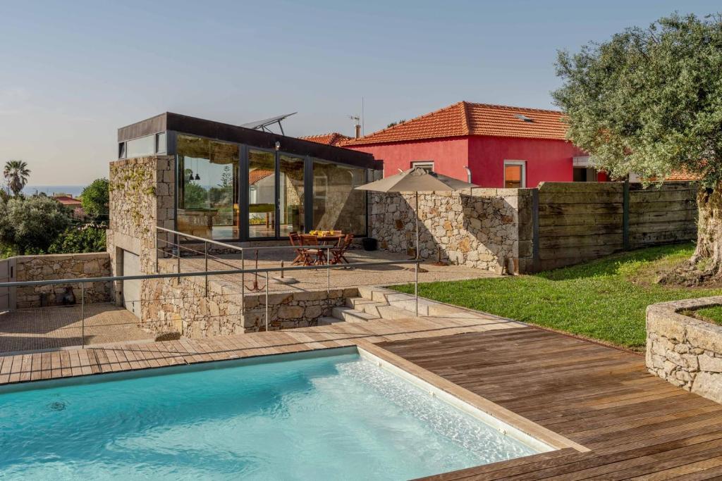 una piscina in un cortile con una casa di Stone by the Sea - Mountain & Beach Retreat w/Pool a Viana do Castelo
