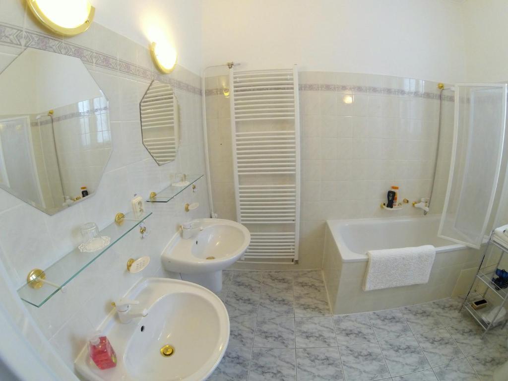 łazienka z umywalką, toaletą i wanną w obiekcie Villa Sonnenstrahl w Mariańskich Łaźniach