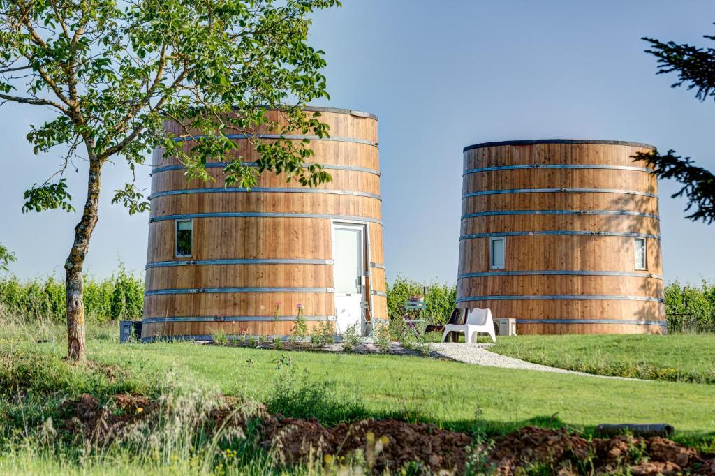 dos silos cilíndricos en un campo con un árbol en Coup 2 Foudres, en Saint-Jean-de-Blaignac