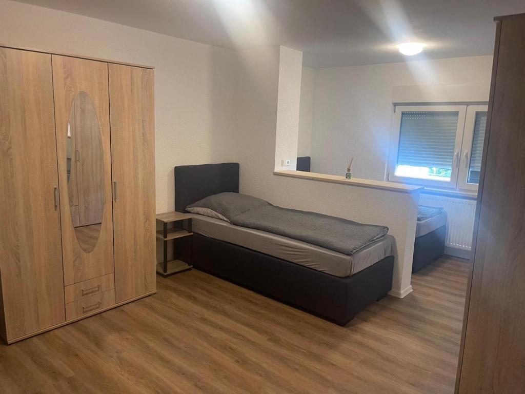 ein kleines Schlafzimmer mit einem Bett und einem Schrank in der Unterkunft Modernes Wohnerlebnis in bester Lage in Heilbronn