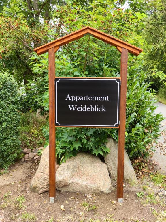 a sign in front of a garden with a sign at Appartement Weideblick in Steinsieken