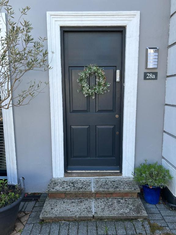 a black front door with a wreath on it at Number 28a in Exmouth