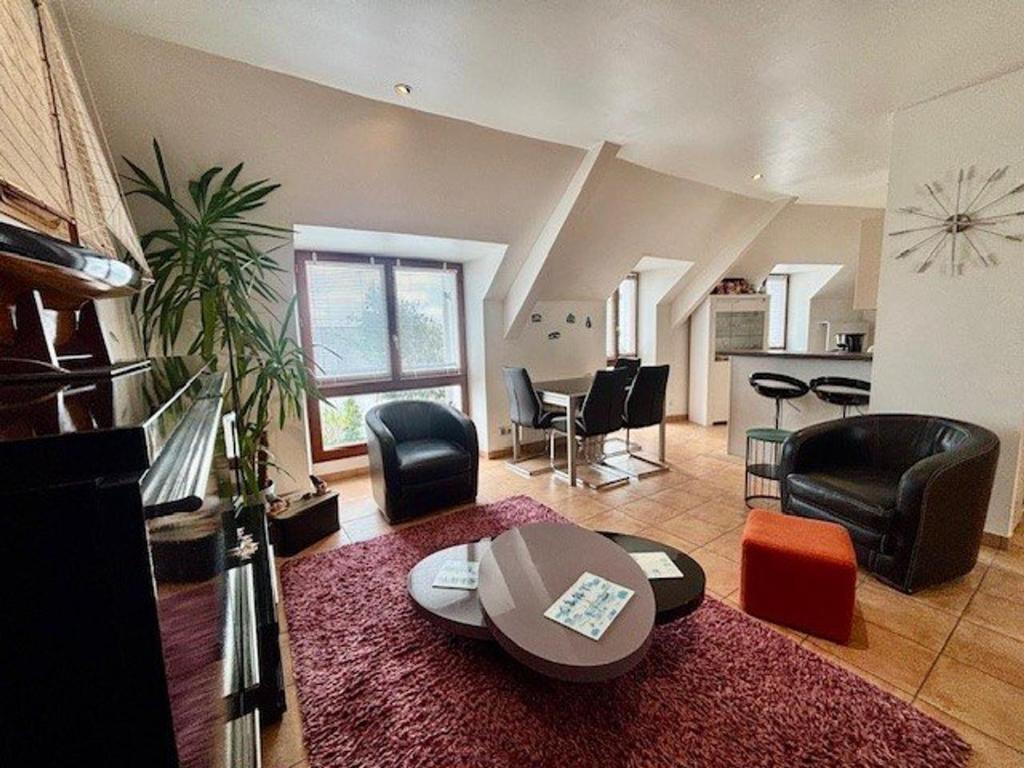 - un salon avec des chaises noires et une table dans l'établissement Quiberon : T3 ensoleillé proche plage, 3 pièces, 2 chambres - FR-1-478-313, à Quiberon