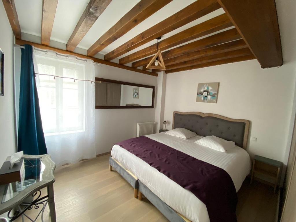 une chambre avec un grand lit et une fenêtre dans l'établissement Maison des Cordeliers, à Bayeux