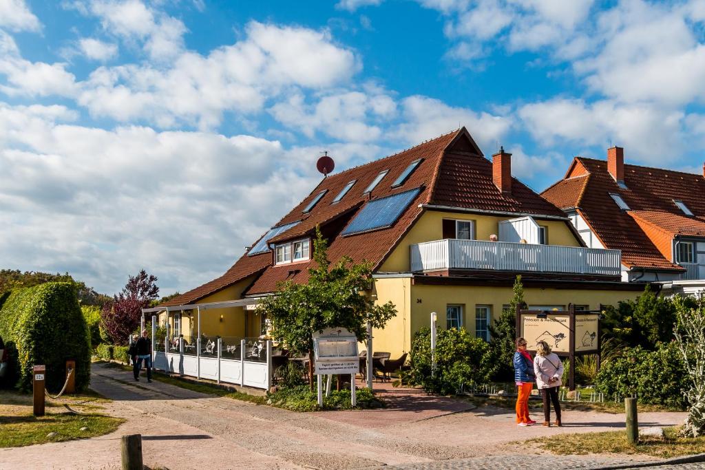 una casa con gente parada frente a ella en Haus Nordlicht, en Ahrenshoop